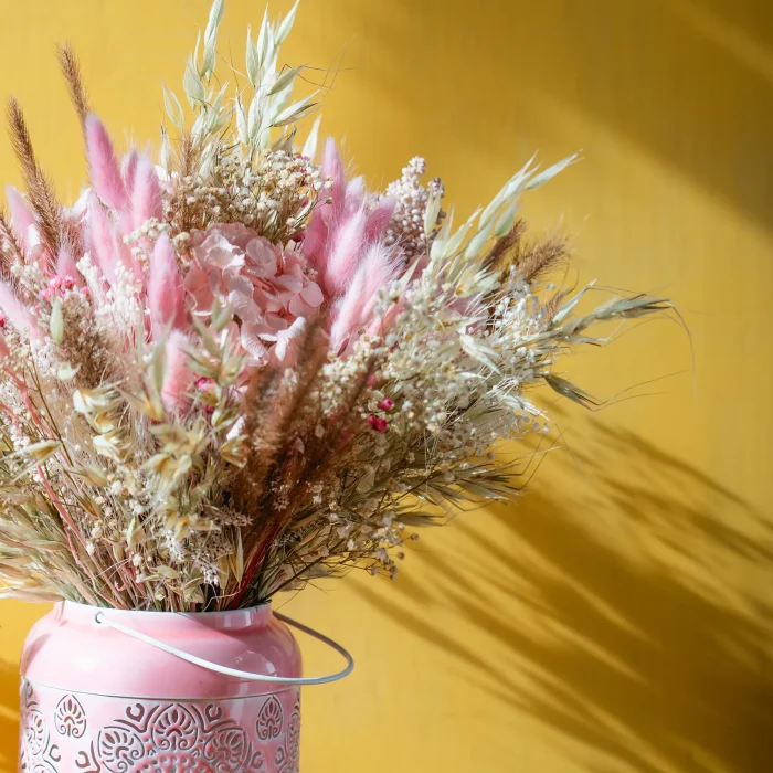 Blomma. Ramo de flores secas y preservadas. Colocadas en un farol para velas que puede usarse como jarrón. Detalle