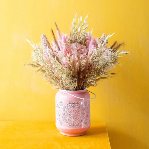 Blomma. Ramo de flores secas y preservadas. Colocadas en un farol para velas que puede usarse como jarrón.